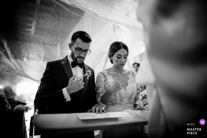 Cutro, Itália Imagem do casamento da noiva e do noivo durante a cerimônia, ajoelhados e orando