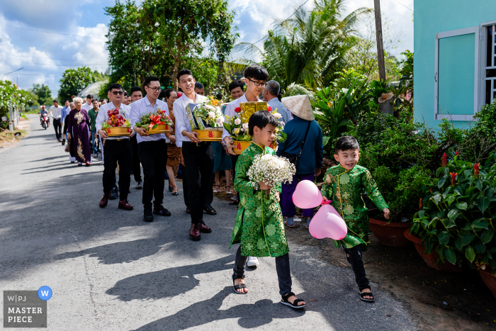 Foto de casamento de duas crianças correndo ansiosamente para a casa da noiva em Sa Dec City