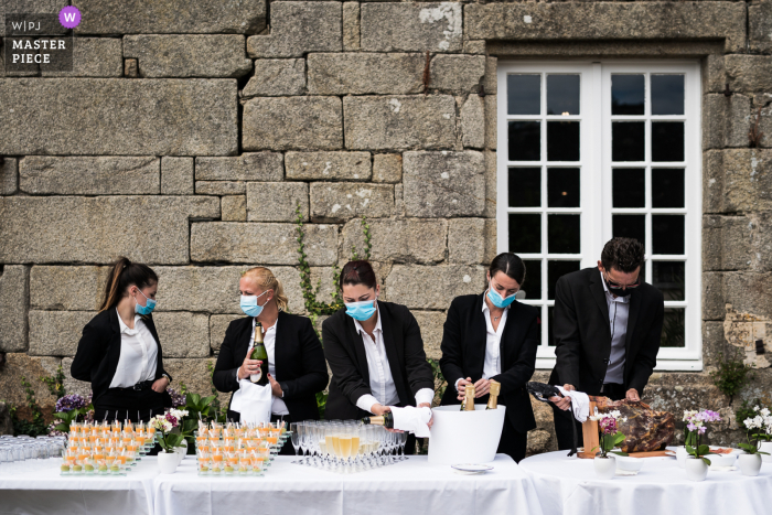 Foto da recepção de casamento na França do Castelo Moelien de máscaras em vendedores Preparando o coquetel