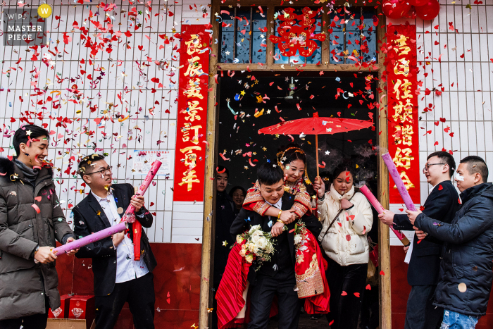 China actuele trouwfoto uit Sichuan in het huis van de bruid van De bruidegom die de bruid draagt, Ze gaan het huis van de bruid verlaten en gaan naar het huis van de bruidegom