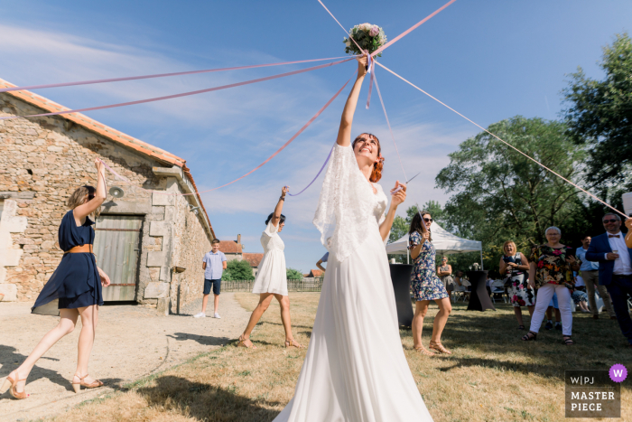 FR outdoor trouwfoto van Domaine de la Gerberie, Vendée of the Game of the wedding linten tijdens een huwelijksreceptie op het Franse platteland