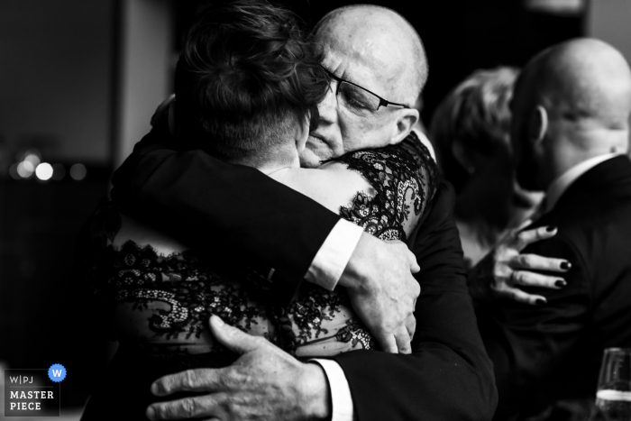 Trouwfoto van Noord Brabant uit Nederland Receptie van de vader van de bruidegom die de bruid knuffelt.