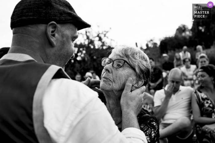 NL trouwfotografie van een buiten Ceremonie in Noord Brabant - Een van de ouders bedanken en op de achtergrond huilen ook de andere gasten