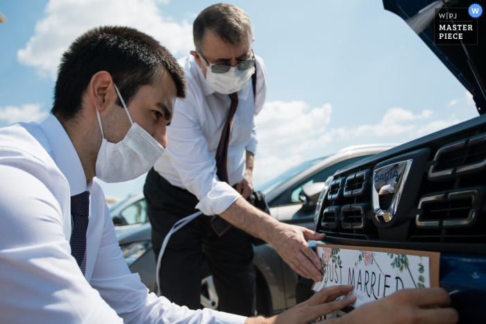 Izer Hotel, Luleburgaz, Turquia, imagem de casamento | Noivo e pai colocando um adesivo de "recém-casado" no carro