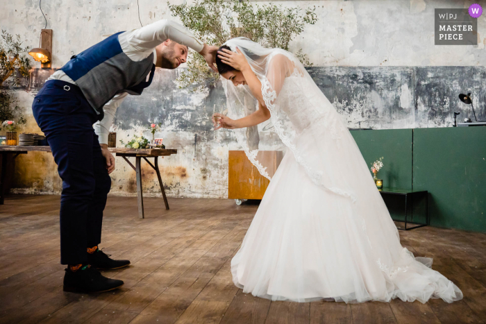 Foto De Casamento Holanda | O noivo tenta consertar algo na cabeça da noiva, após a cerimônia