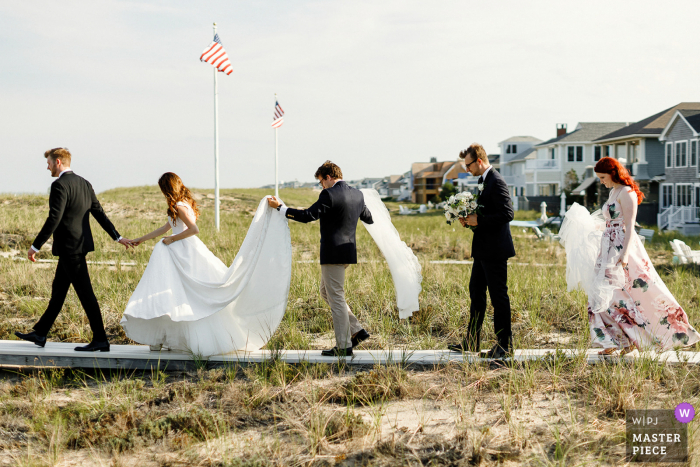 Cape Cod huwelijksfotografie | Bruid en bruidegom en hun vrienden die naar het strand gaan