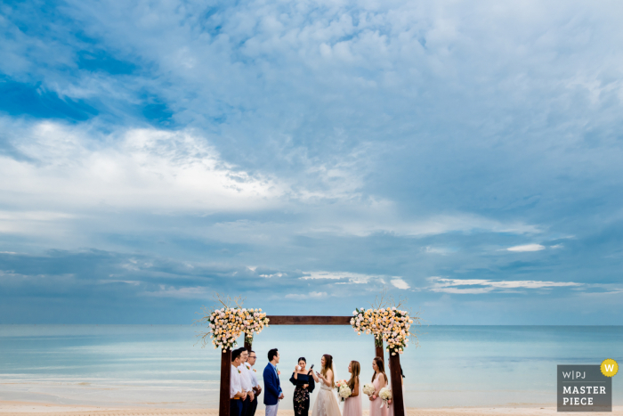 Fotografia de casamento na praia de uma cerimônia no Vietnã mostrando Nunca há melhor hora ou lugar para o amor verdadeiro