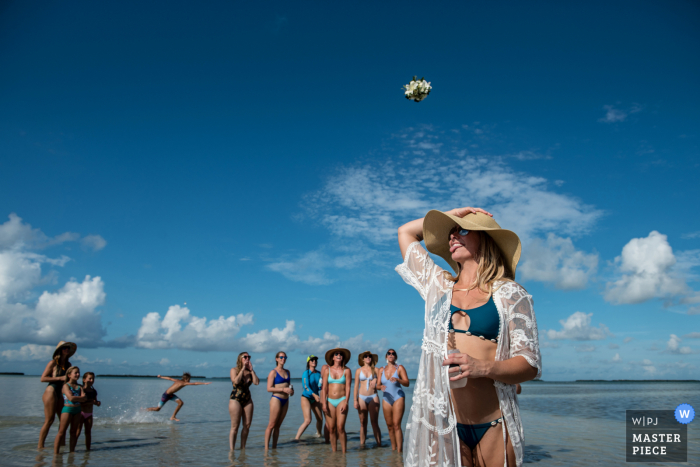 Foto del matrimonio sulla spiaggia della Florida di Marvin Key, Key West che mostra il lancio del bouquet da sposa piccolo