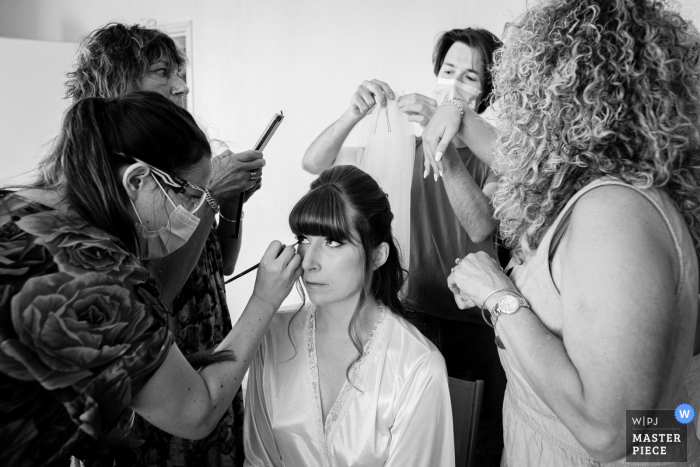 Preparando a foto do casamento de Château de Nolet, Aucamville, França, da noiva recebendo ajuda com cabelo e maquiagem