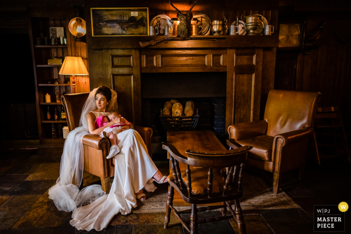 IE trouwfoto bij het BrookLodge Hotel, Wicklow, Ierland van een "Nap-gevangen" Bruid op zoek naar haar eigen cocktail uur als haar peuter dutjes in haar armen