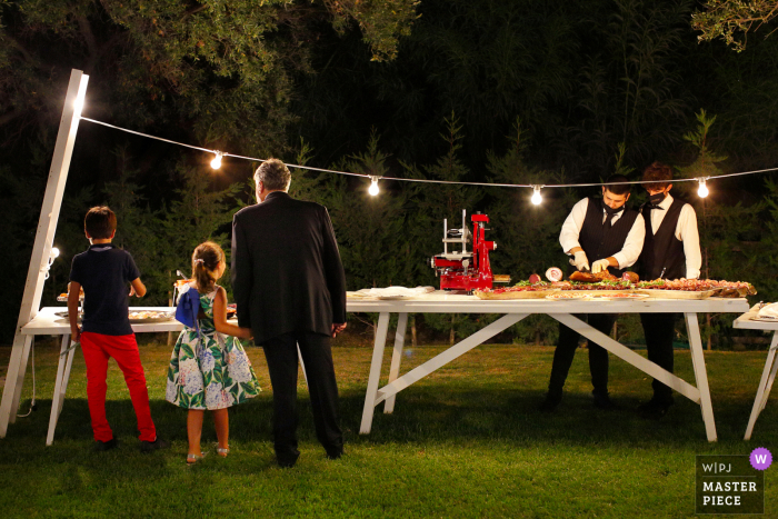 Foto de la boda en el lugar de la recepción al aire libre de Ristorante La Cascina, Roccella Jonica en la cena / recepción de los invitados a la boda observando a los camareros y las especialidades de Calabria del buffet de aperitivos