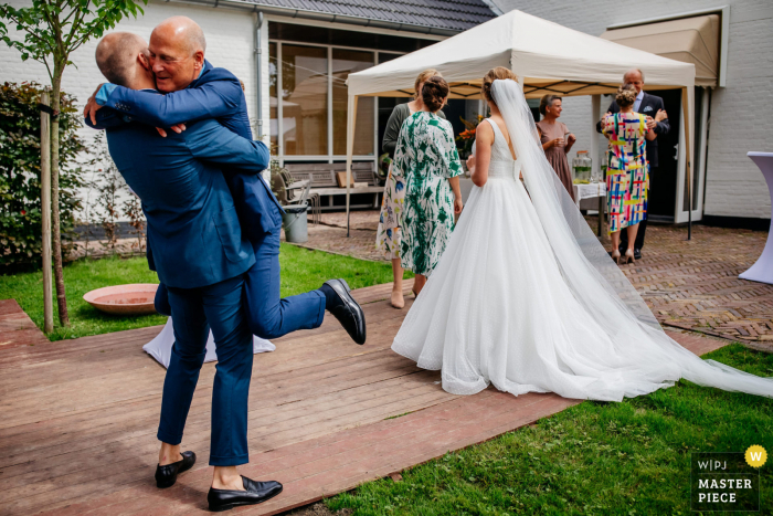 Utrechtse trouwfoto van een Nederlandse huis bruidegom en vader knuffel