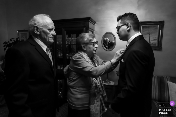 Mantova, Italy Wedding Image | The mother of the groom, very sick and supported by her husband, expresses the desire to get up to check that the child is in order