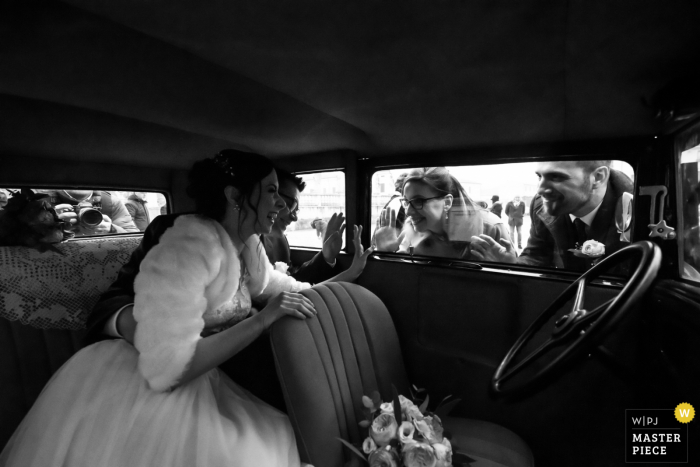 Imagen de boda de Mantova, Italia | Mientras los novios esperan la llegada del conductor, los amigos más cercanos de la pareja se acercan para saludar