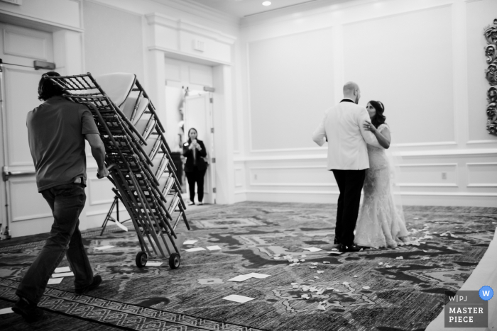 Texas wedding photo from The Westin Riverwalk, San Antonio of the Couple practicing the first dance as chairs are removed from a hotel ballroom 