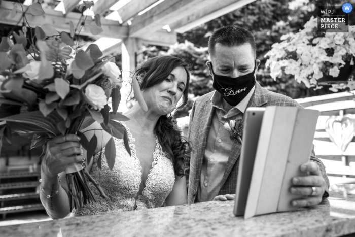 foto de la boda de una ceremonia en el patio trasero en Ayr, Ontario, Canadá, después de la ceremonia, los novios se reunieron con todos los invitados que no pudieron asistir a la boda debido al COVID-19 en un servicio de transmisión en su iPad.