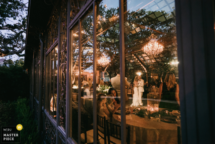 wedding photography from the Reception at The Bryan Museum, Galveston showing the Father of the bride and bride first dance captured from outside venue looking in 