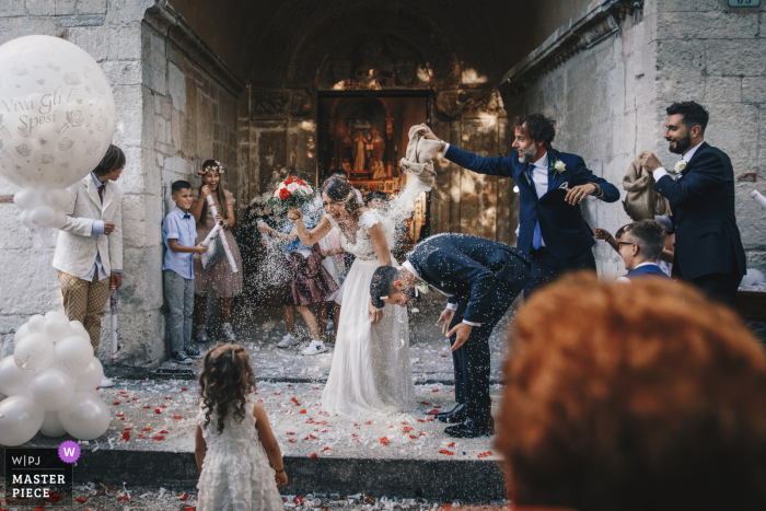 fotografia de casamento de Chiesa of the Wedding arroz atirado sobre os noivos