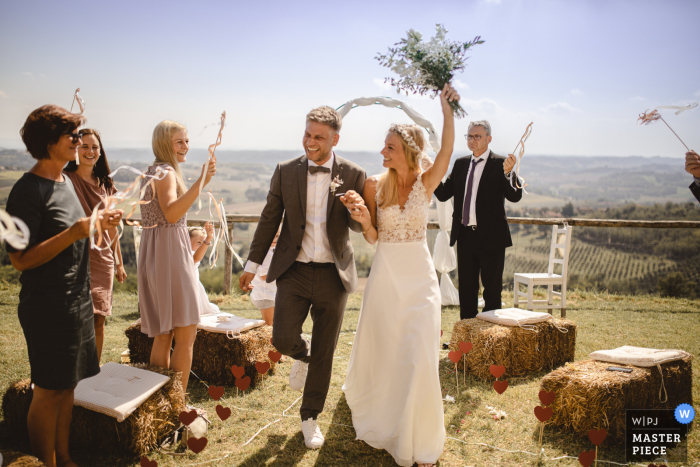 Fotografía de bodas en la playa al aire libre de Agriturismo Crealto, Alfiano Natta, Italia mostrando - Here comes the Bride & Groom