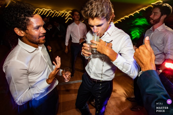 Fotografia de festa de casamento em um local privado em La Romieu, Gers, França como Um homem está bebendo enquanto as outras bebidas se invertem