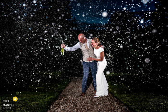 wedding photography from Kasteel Maurick in Vught of The wedding couple popping the champagne 