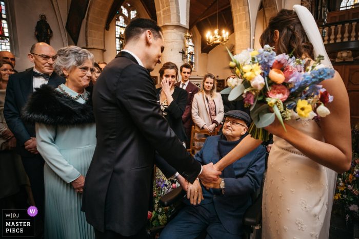 Trouwfotografie in België | de vader van de bruid roept een droevige reactie op bij het binnengaan van de kerk (hij stierf een maand later door een tumor)