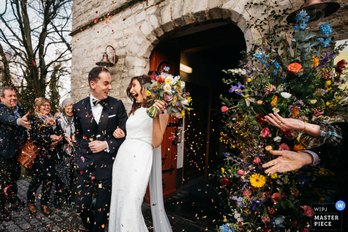 fotografia de reportagem de casamento de uma igreja de Flandres com os noivos saindo da cerimônia