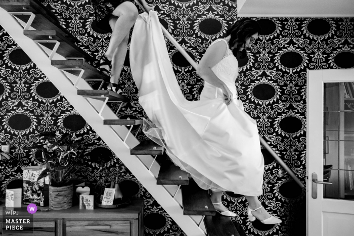 Netherlands bride descends the stairway at home as she prepares to leave for the wedding ceremony