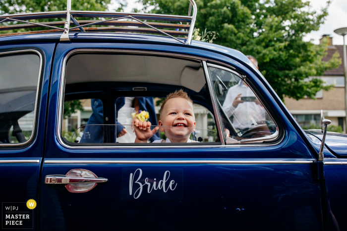 Netherlands wedding photography of a kid in a wedding car with a sign 'bride' Netherlands wedding photography of a kid in a wedding car with a sign 'bride'