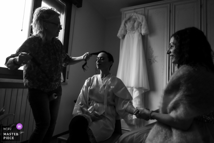 As the start of the ceremony approaches, a little agitation rises, immediately sedated by the witness who shakes the bride's hand and allows her to complete the hairstyle at the House of the bride - San Benedetto Po - Mantua - Italy