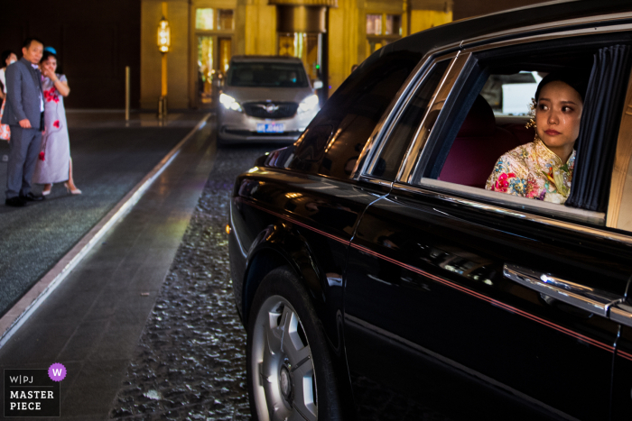 Liaoning China image of the bride in the back of a car departing