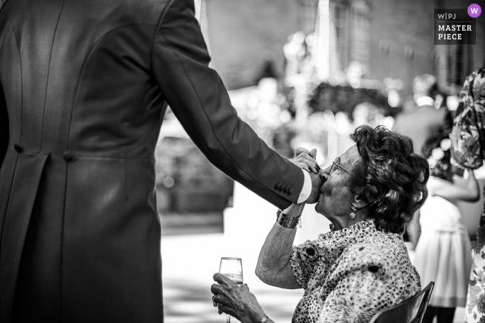 Emotie van de bruidegom die zijn hand kust bij Manor of the Guard