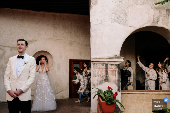 Afbeelding van de bruid die emotioneel wordt voordat ze voor het eerst kijkt terwijl haar vrienden naar Quinta Real in Oaxaca City kijken