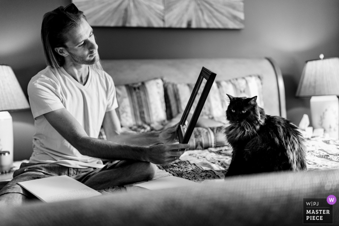 Private Residence wedding image from Asheville, NC as The groom writes his bride a poem, but uses the frame to compose his cat