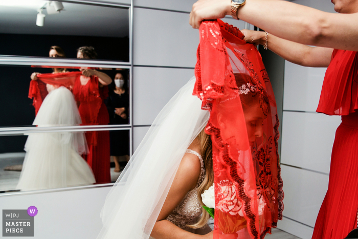 L'immagine che mostra la sposa è ricoperta di rosso secondo le tradizioni di questo matrimonio di Istanbul