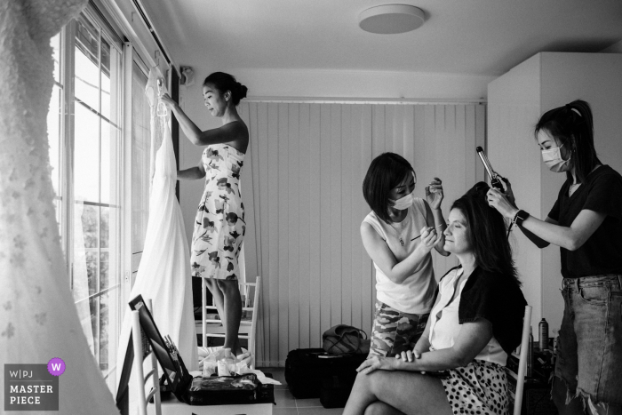 Por um momento durante a preparação da noiva, a noiva estava pendurando seu vestido de casamento, enquanto os MUAs estavam maquiando a melhor amiga da noiva em Sai Kung, Hong Kong (casa dos noivos)