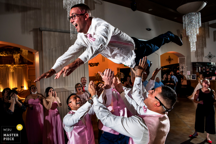 Bild des Hochzeitsortes des Bräutigams, der von Trauzeugen im Bella Sera Event Center von Brighton, CO in die Luft geworfen wird