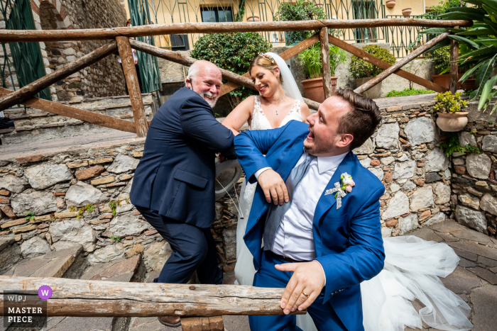 Os cônjuges, após a cerimônia, cumprimentam o celebrante em total estilo anticovídico no Palácio dos Duques de Santo Stefano - Taormina