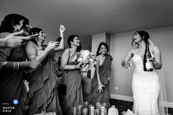 Image of the bride opening a champagne bottle at the Hilton Chicago/Oak Brook Hills Resort & Conference Center