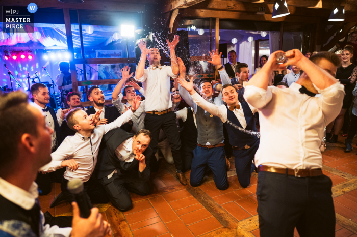 Ein slowenisches Hochzeitsempfangsbild, auf dem der Bräutigam ein Wasser anstelle eines Strumpfbandes wirft