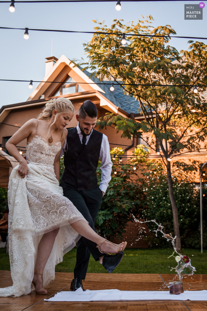 Sofia, Bulgaria, private home and garden wedding reception image of the bride and groom kicking together Sofia, Bulgaria, private home and garden wedding reception image of the bride and groom kicking together
