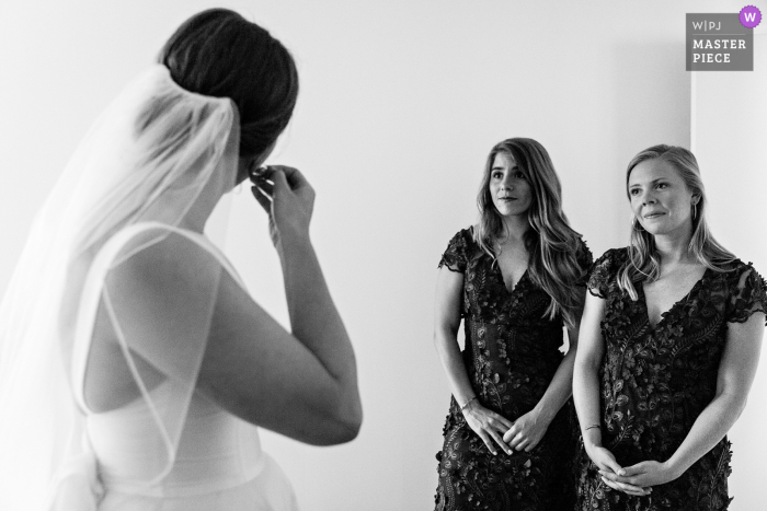 Blue Hill, Maine, les demoiselles d'honneur regardent pendant que la mariée met ses bijoux avant le mariage