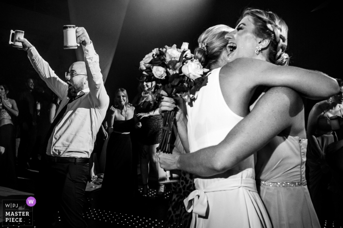 A Happy Brazil Godfather celebrates when he sees his girlfriend taking the bouquet at the wedding reception