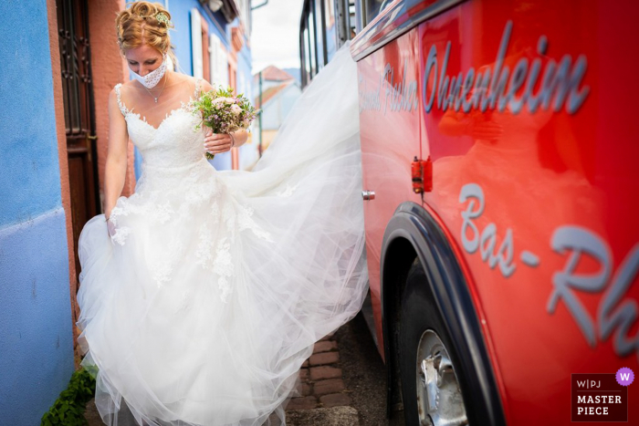 Huwelijksfotografie in Bassemberg - Elzas van de bruid Op weg naar het stadhuis met een rode bus