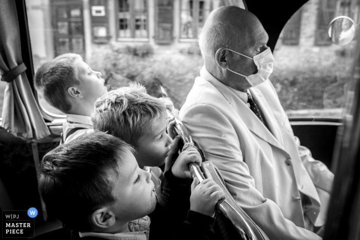 Trouwfoto uit de Elzas tijdens transport in een oude bus met daarop de roadtrip van de jongens