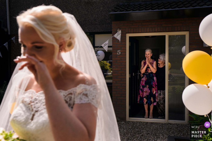 The mother, standing in the doorway is so happy to see her daughter, who is emotional on her wedding day in the Netherlands