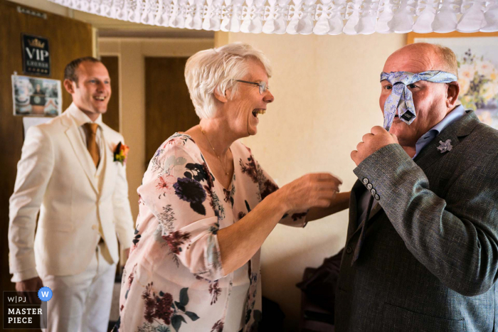 Fotografo di matrimoni olandesi "mettere la cravatta non è così facile e la madre dello sposo si sta divertendo sulla scena"