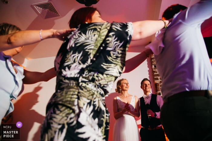 Belgium bride and groom watch their guests perform a surprise act during their evening speech 