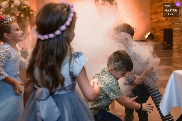 Bambini che giocano con la macchina del fumo durante il primo ballo al Best Western Inter Expo Hotel di Sofia, Bulgaria