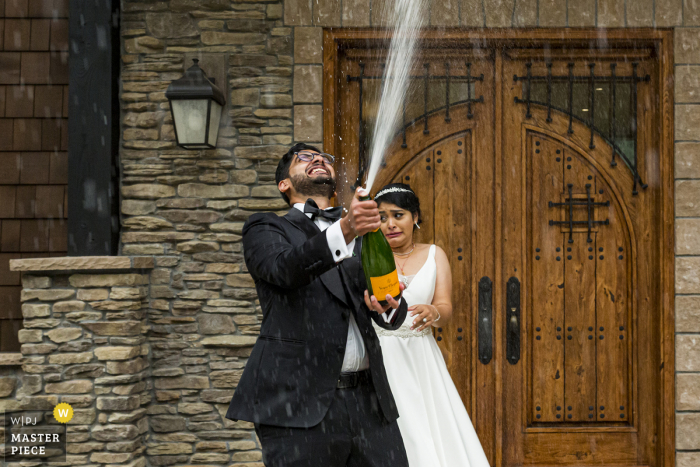 Wedding photography of a Washington	bride and groom celebrating with spraying some champagne